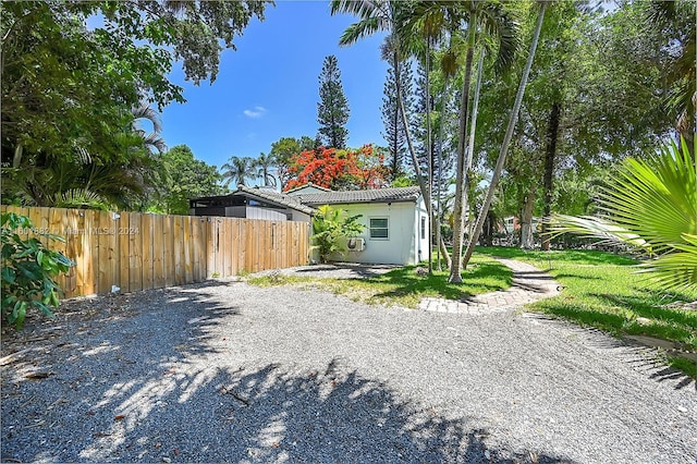view of home's exterior featuring fence, stucco siding, and a tile roof