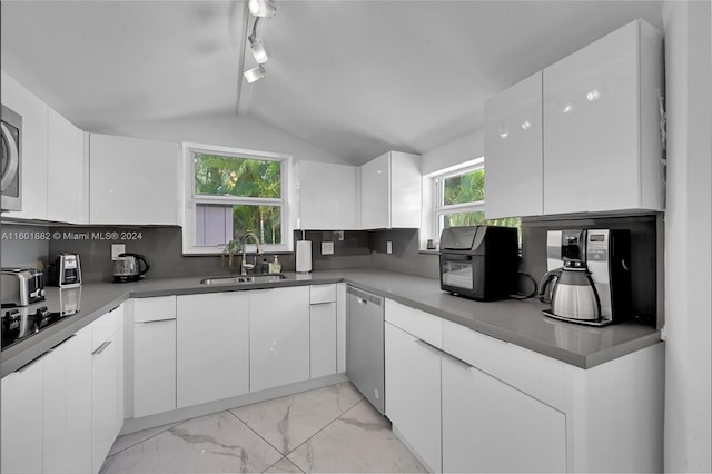 kitchen featuring a sink, marble finish floor, vaulted ceiling, white cabinetry, and stainless steel dishwasher