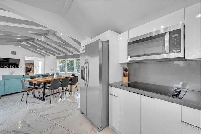 kitchen with lofted ceiling with beams, stainless steel appliances, and white cabinets