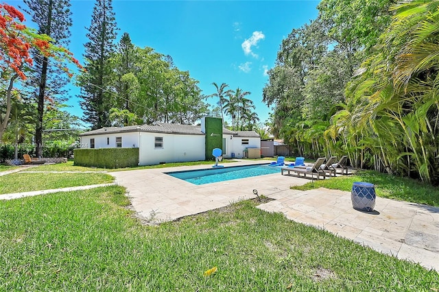 pool featuring a lawn, fence, and a patio area
