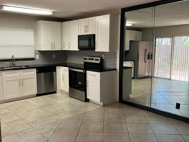 kitchen featuring appliances with stainless steel finishes, white cabinetry, pendant lighting, and sink