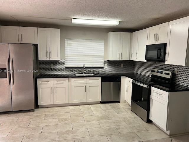 kitchen featuring sink, light tile patterned floors, a textured ceiling, white cabinetry, and stainless steel appliances