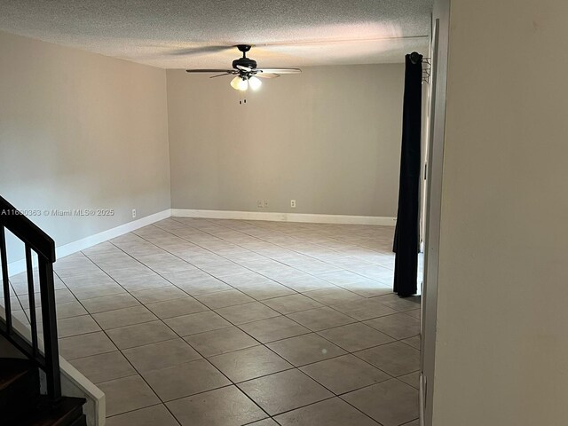 tiled spare room with ceiling fan and a textured ceiling