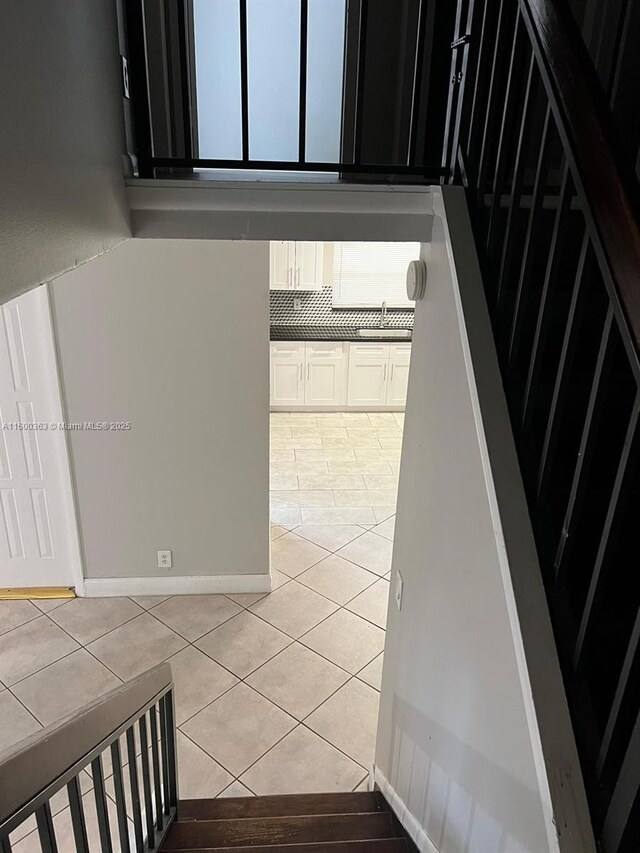 stairway with tile patterned flooring and sink