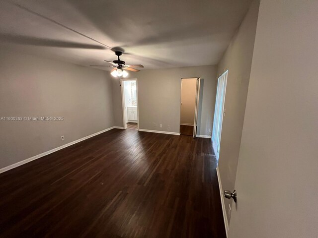 spare room featuring ceiling fan and dark wood-type flooring