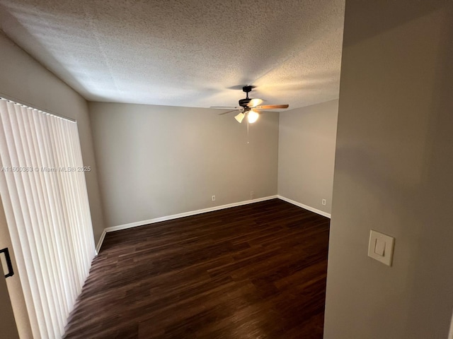 spare room featuring a textured ceiling, ceiling fan, and dark wood-type flooring