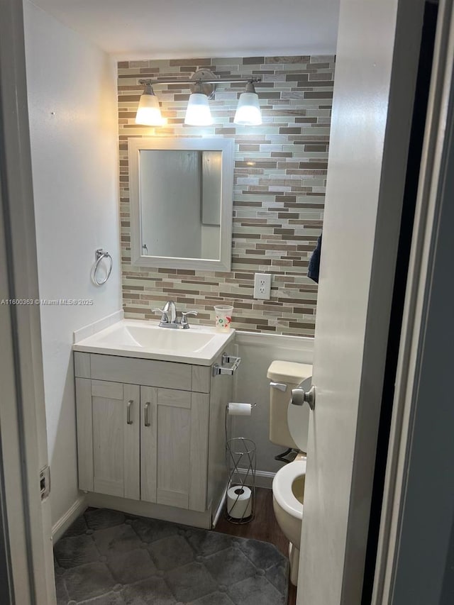 bathroom featuring decorative backsplash, toilet, and vanity