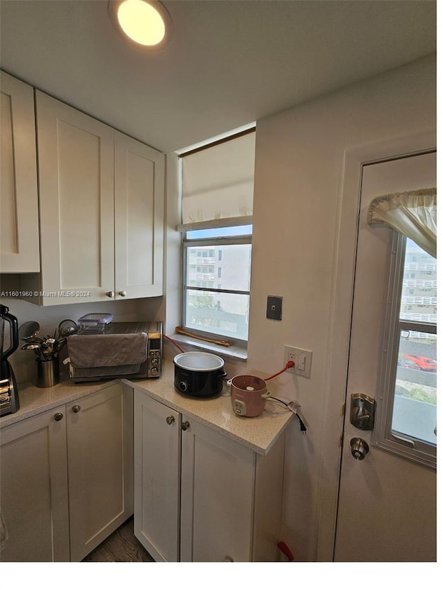 kitchen featuring light stone counters and white cabinets