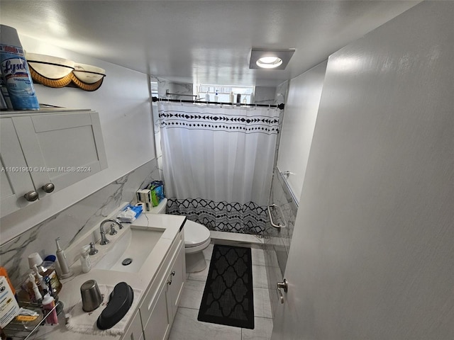 bathroom with curtained shower, tasteful backsplash, tile patterned floors, toilet, and vanity