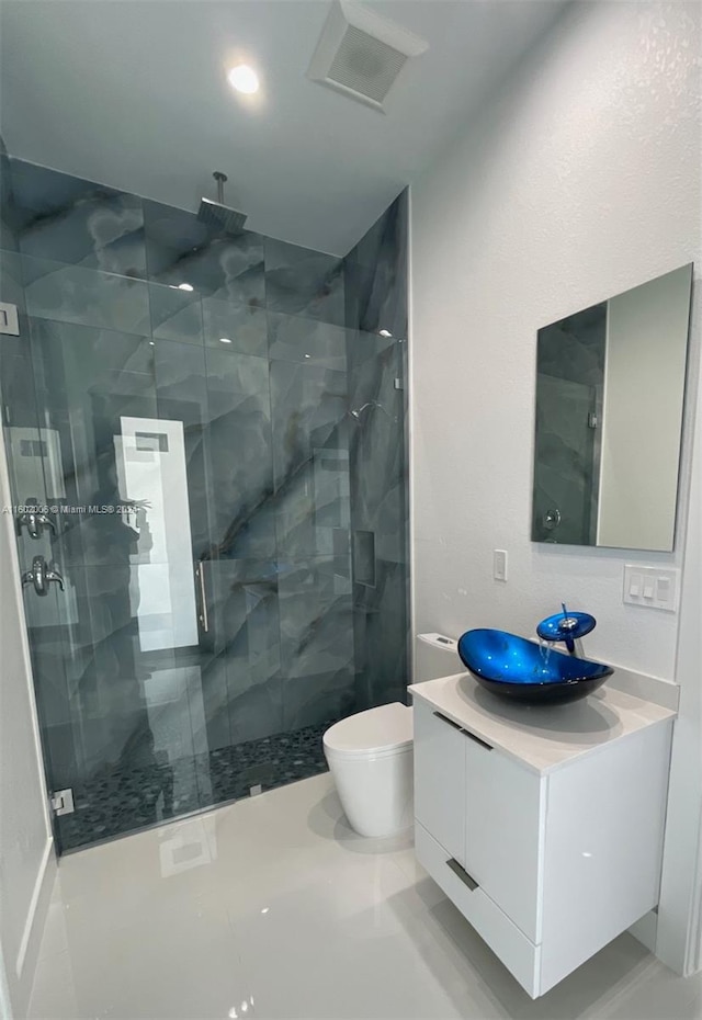 bathroom with vanity, toilet, and a shower with shower door