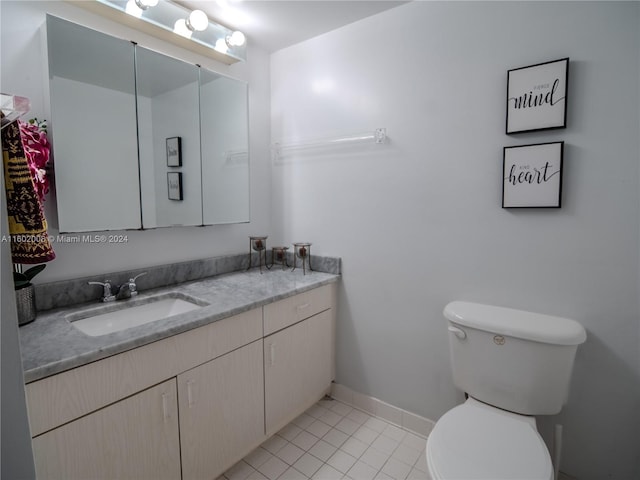 bathroom with tile patterned flooring, vanity, and toilet