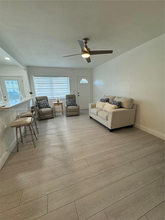 living room with ceiling fan and light hardwood / wood-style flooring