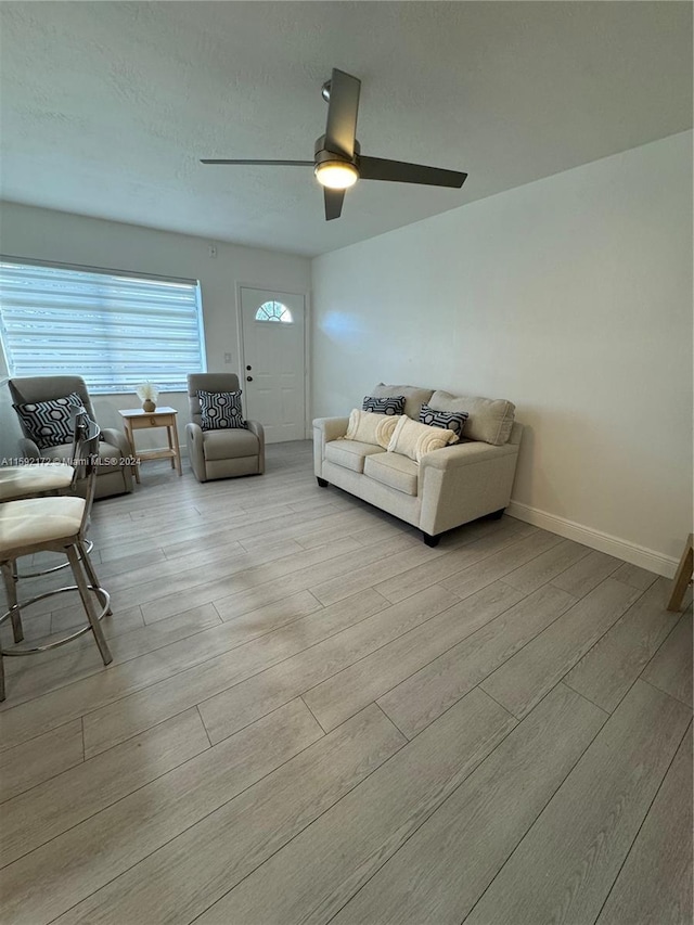 living room with ceiling fan and light wood-type flooring