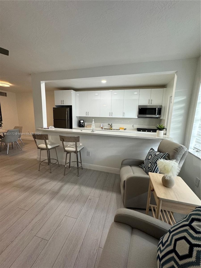 living room featuring a textured ceiling and light wood-type flooring