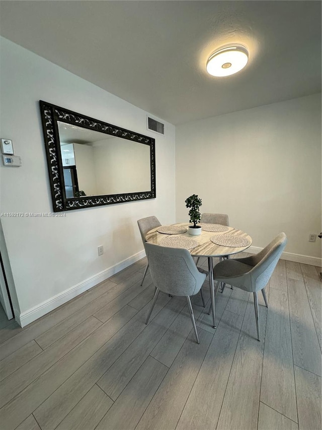 dining space with wood-type flooring