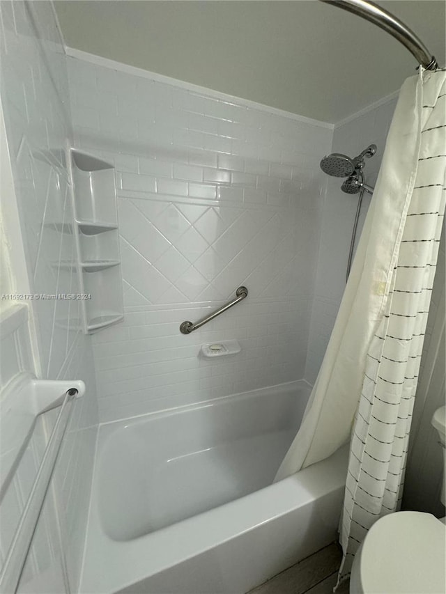 bathroom featuring shower / bath combination with curtain and toilet