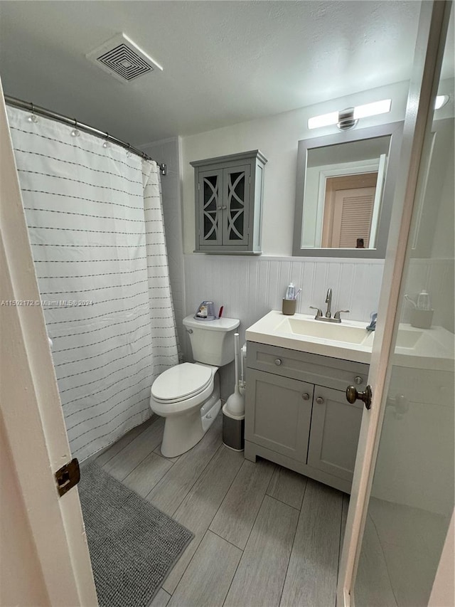 bathroom with a shower with curtain, vanity, and toilet