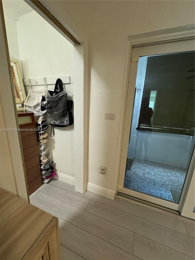 corridor with light hardwood / wood-style floors