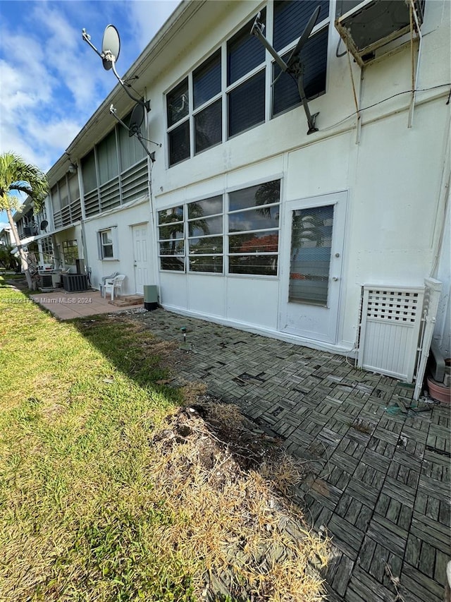 rear view of house with a lawn, central air condition unit, and a patio