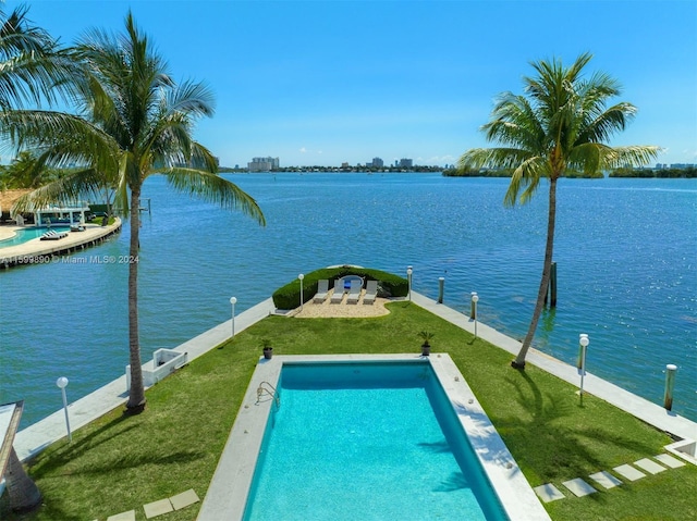 view of swimming pool featuring a lawn and a water view