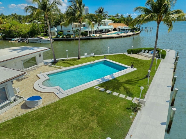 view of pool with a dock, a water view, and a yard