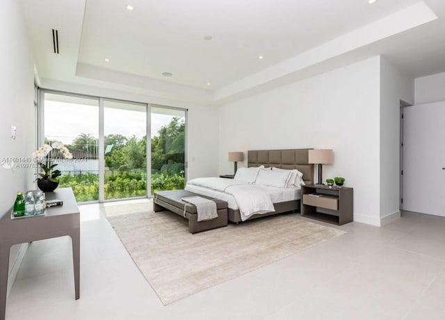 bedroom featuring access to outside and a tray ceiling