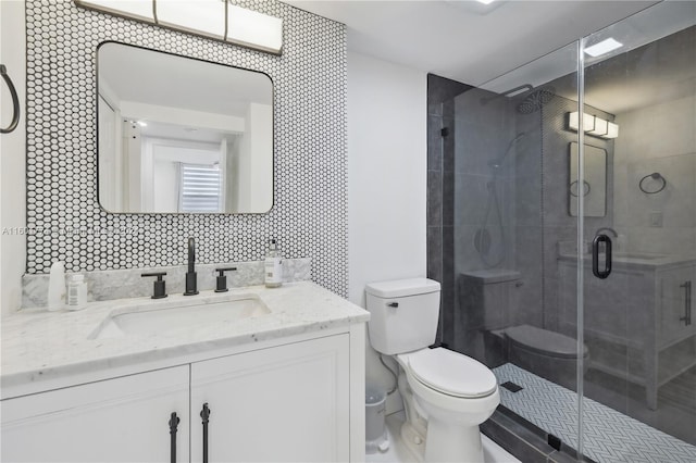 bathroom featuring vanity, toilet, decorative backsplash, and walk in shower