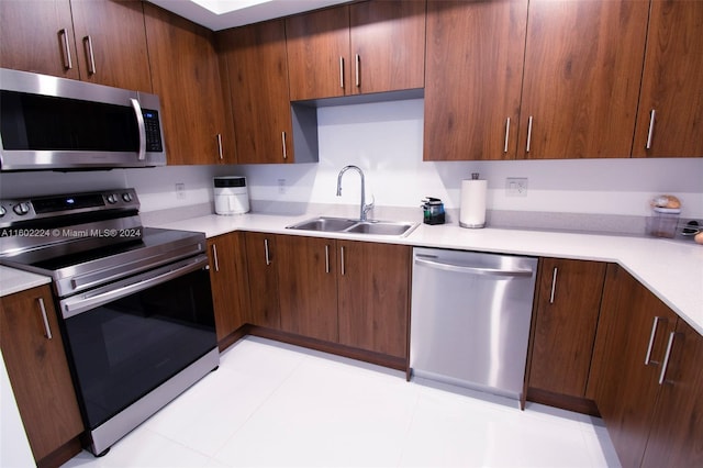 kitchen featuring sink, light tile flooring, and appliances with stainless steel finishes