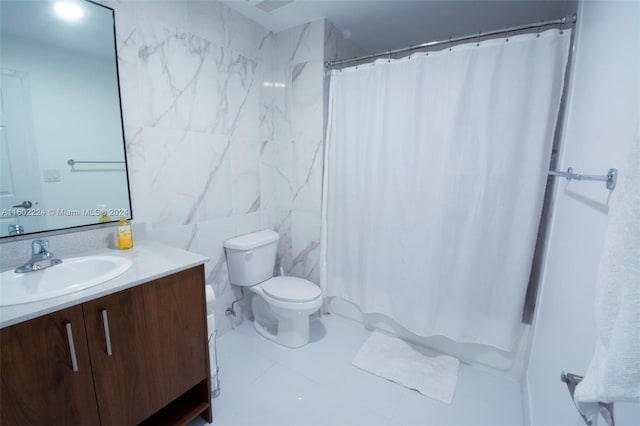 bathroom with tile flooring, tile walls, toilet, and large vanity