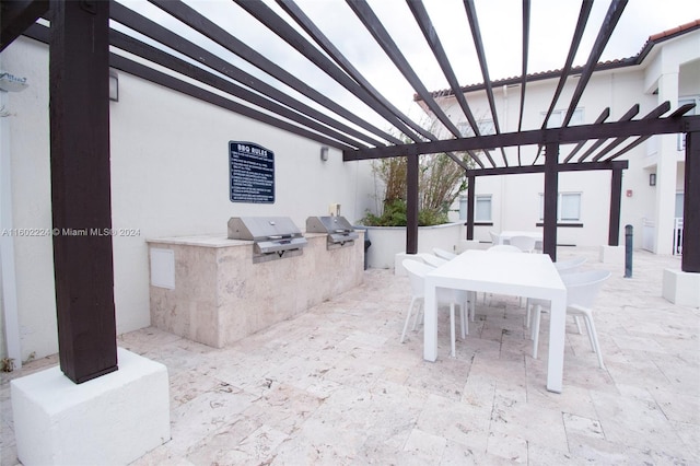 view of patio featuring a pergola, a grill, and an outdoor kitchen