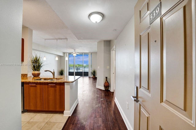 kitchen with expansive windows, sink, and light wood-type flooring