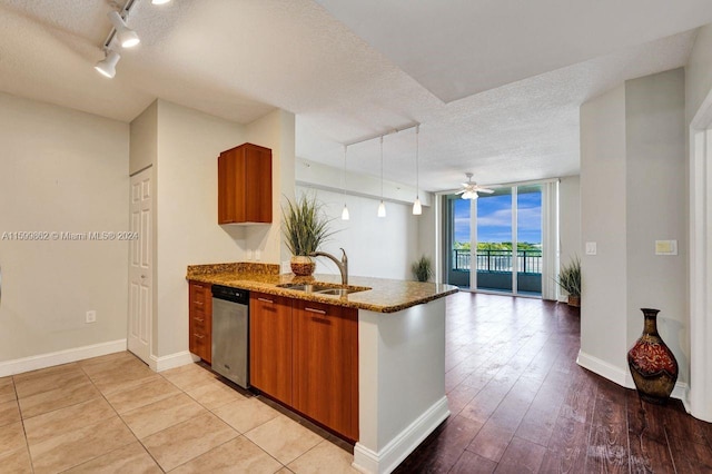 kitchen featuring sink, a textured ceiling, stainless steel dishwasher, kitchen peninsula, and expansive windows