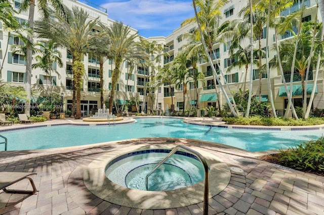 view of swimming pool featuring a hot tub