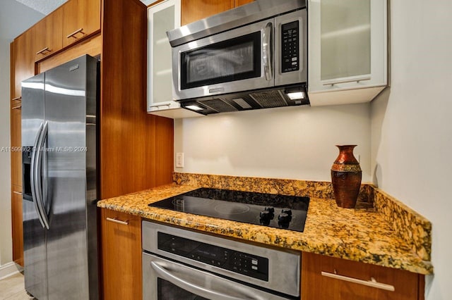 kitchen featuring stainless steel appliances and light stone countertops