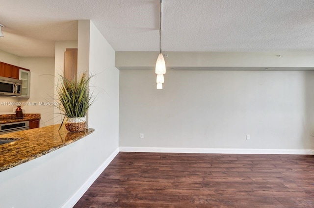 dining room featuring sink, dark wood-type flooring, and a textured ceiling