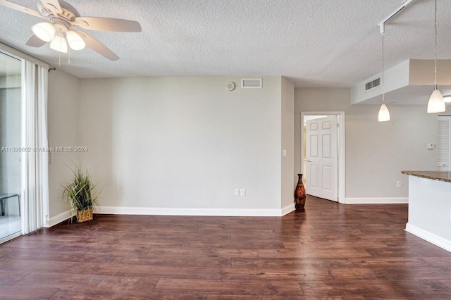 empty room with dark hardwood / wood-style flooring, ceiling fan, and a textured ceiling