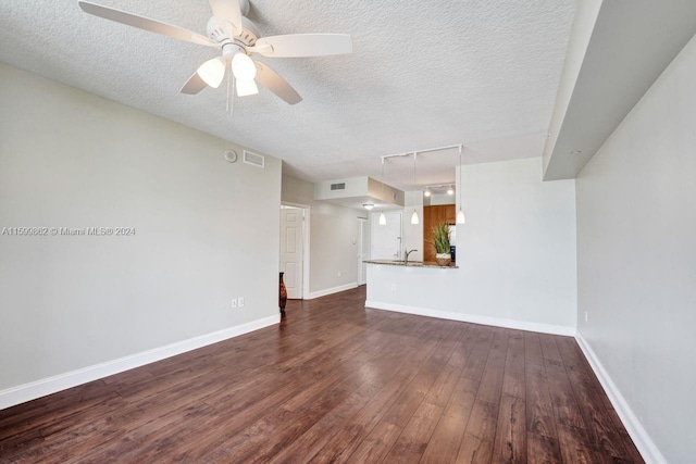 unfurnished living room with ceiling fan, dark wood-type flooring, sink, and a textured ceiling