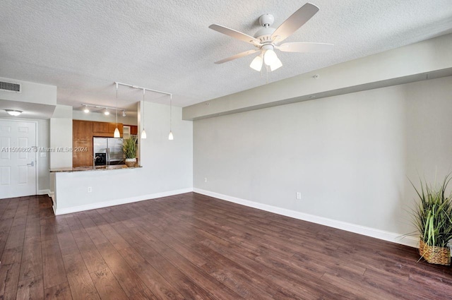 unfurnished living room featuring ceiling fan, dark wood-type flooring, track lighting, and a textured ceiling