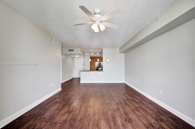 unfurnished living room featuring ceiling fan, a textured ceiling, and dark hardwood / wood-style flooring