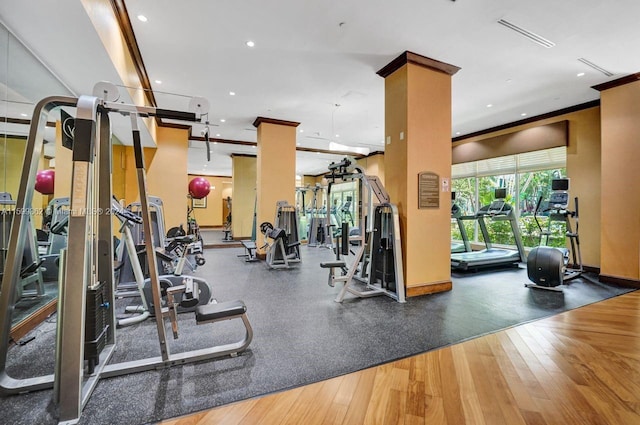 workout area with crown molding and wood-type flooring