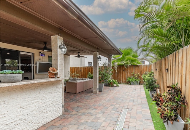 view of patio with an outdoor living space and ceiling fan