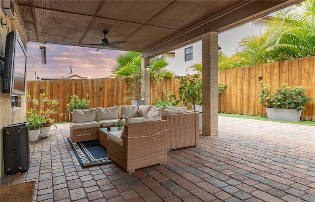 patio terrace at dusk with an outdoor living space and ceiling fan