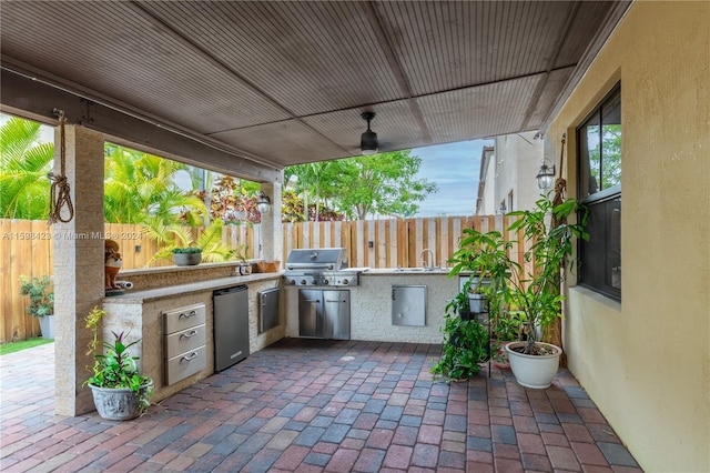 view of patio / terrace with a grill, sink, and exterior kitchen