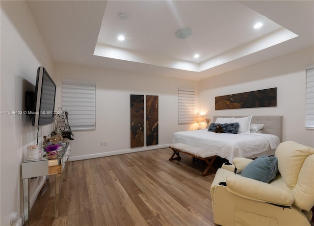 bedroom featuring a raised ceiling and hardwood / wood-style floors