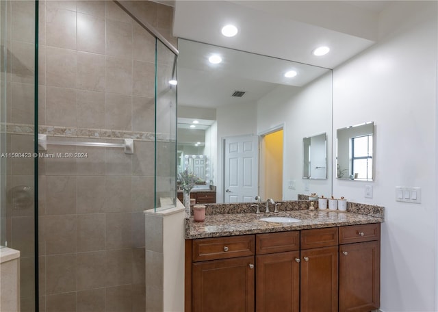 bathroom featuring vanity and tiled shower