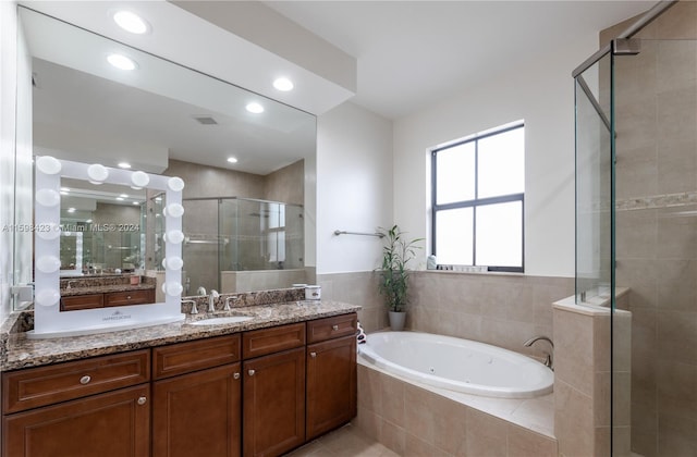 bathroom with vanity and separate shower and tub