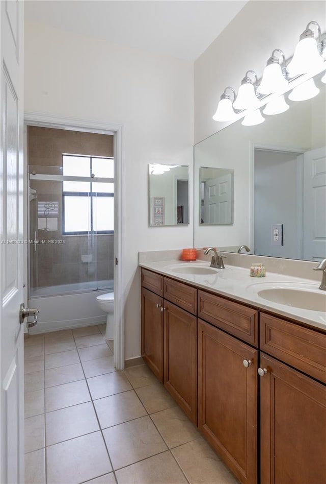 full bathroom featuring tile patterned flooring, vanity, bath / shower combo with glass door, and toilet