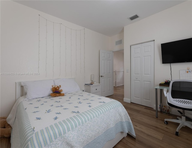 bedroom featuring wood-type flooring and a closet