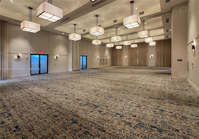 unfurnished room featuring a towering ceiling and a tray ceiling