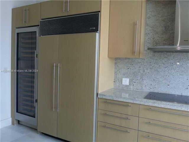 900 Brickell Key Blvd Unit 2803, Miami, FL 33131 - kitchen featuring paneled built in refrigerator, wall chimney range hood, decorative backsplash, light stone counters, and black electric stovetop